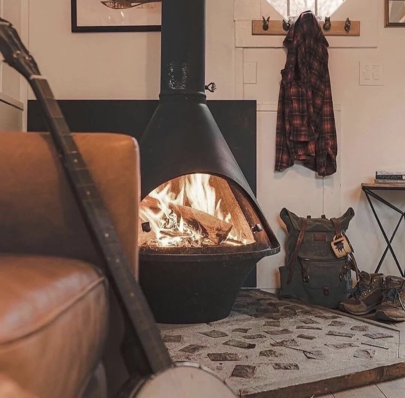 A sculptural black fireplace glowing in a warm retreat interior